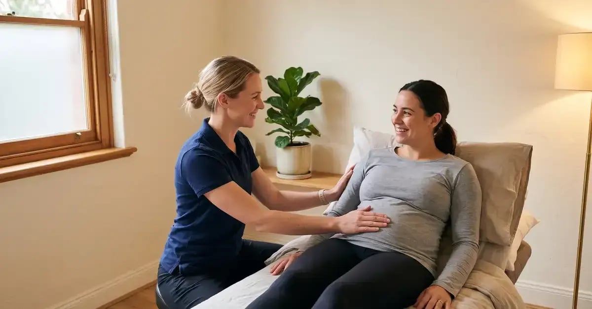 Female chartered physiotherapist gently assessing a new mother's abdomen during a postnatal recovery appointment